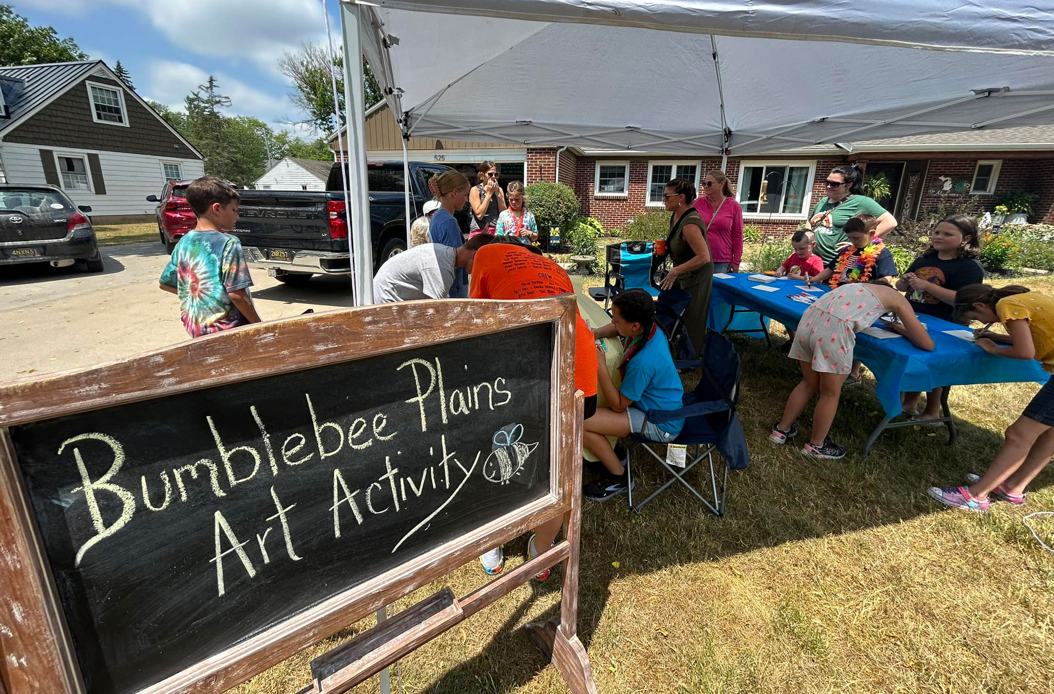 People gathering under a tent at the Bumblebee Plains Art Activity