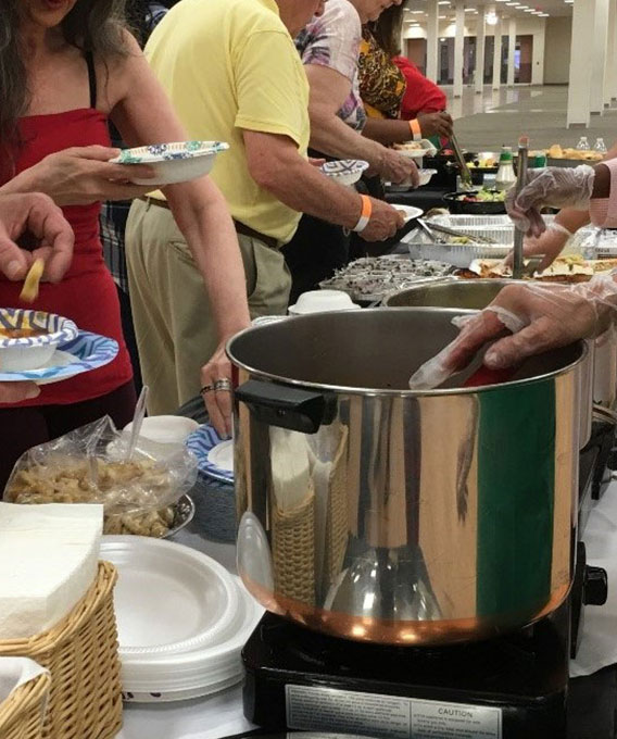 Photo of people serving food at a potluck