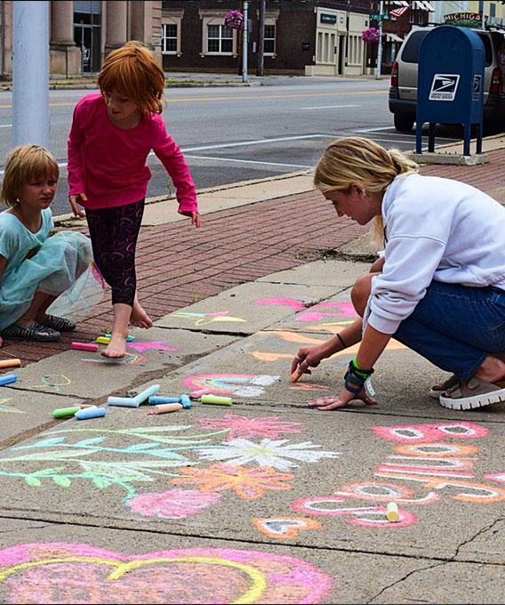 People drawing with sidewalk chalk