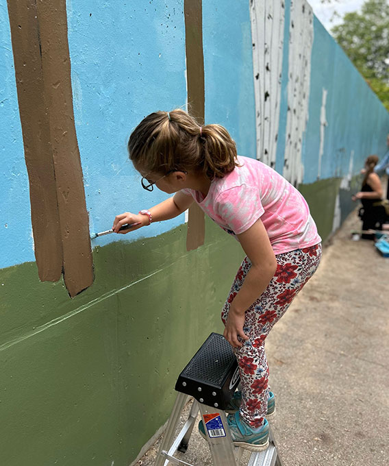 Kid painting a mural