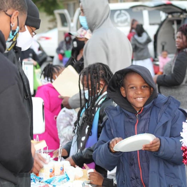 Young smiling boy holding a paper plate at a cookout