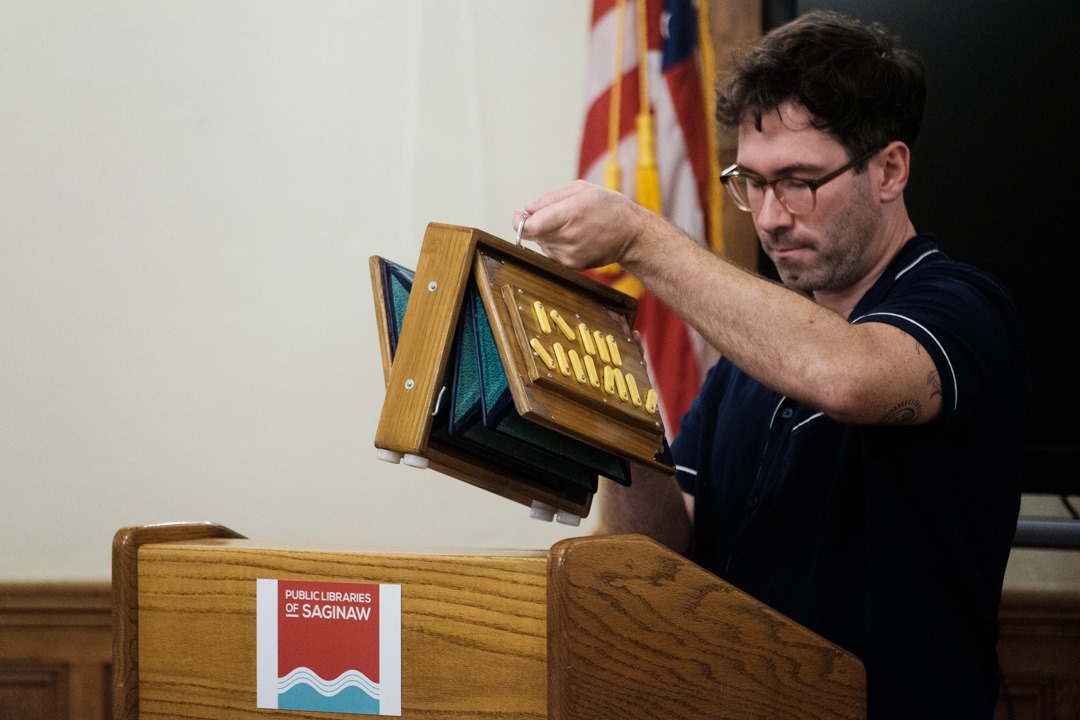 Man presenting a wooden folding box