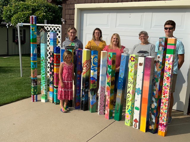 People standing with completed art poles