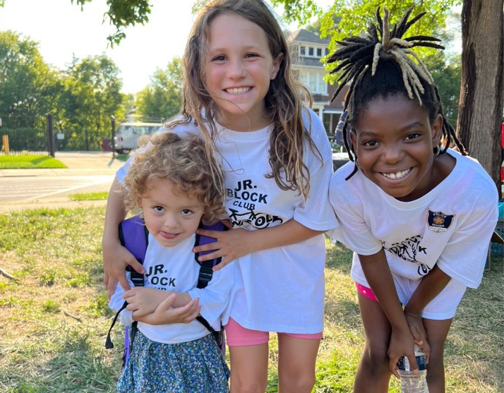 Three young girls hugging and smiling