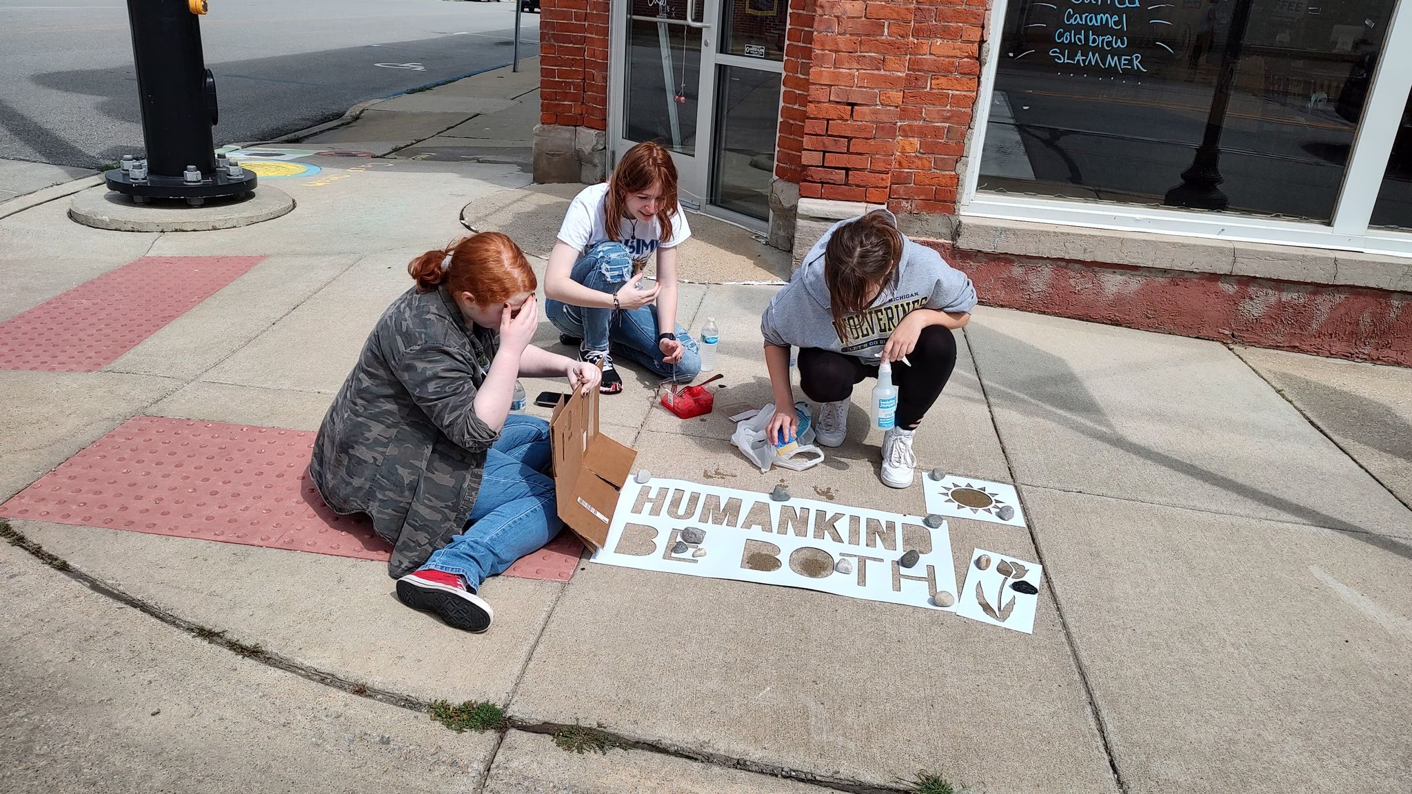 girls working around a stencil on the sidewalk