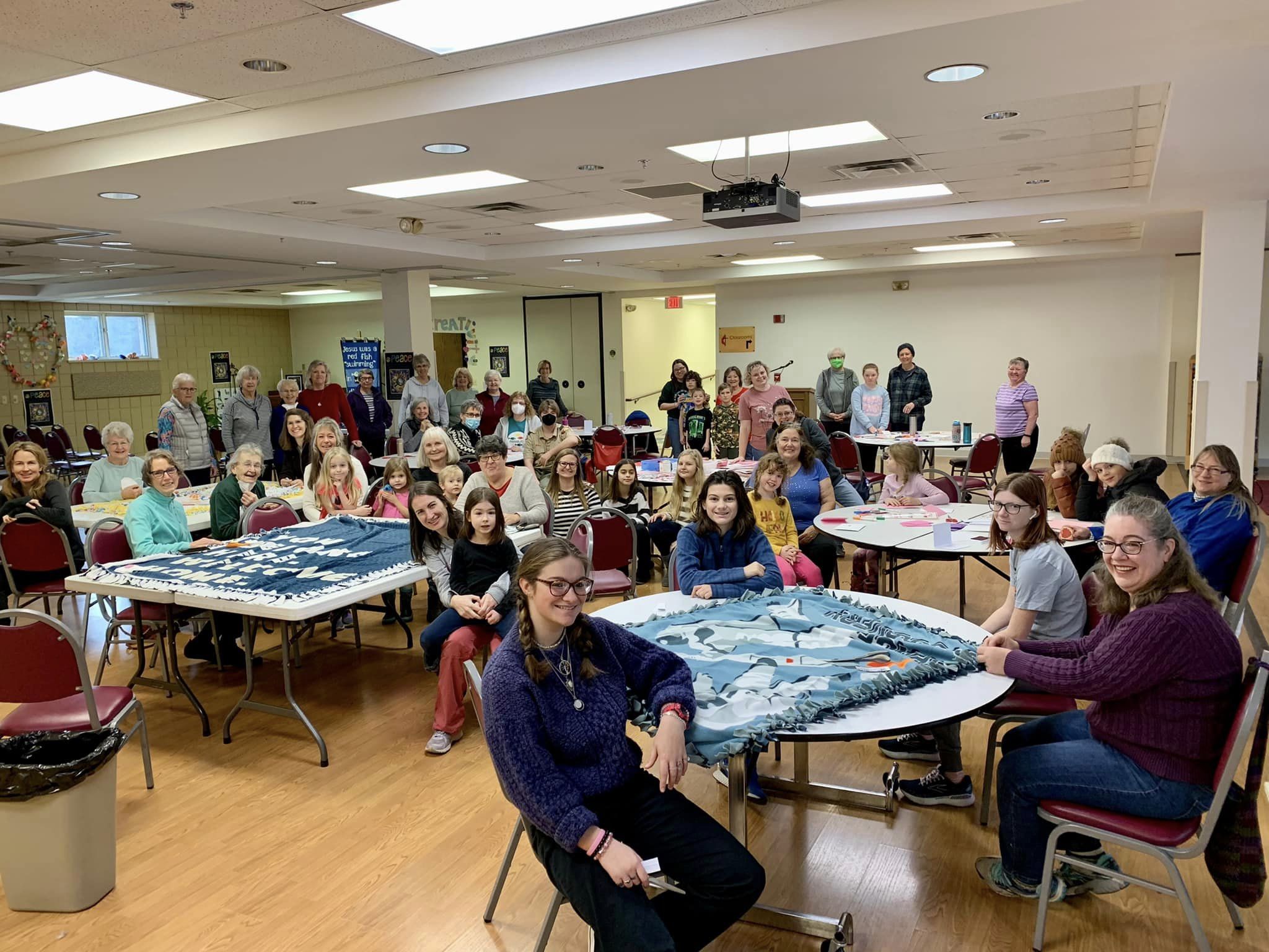 Room full of people sitting around tables crafting