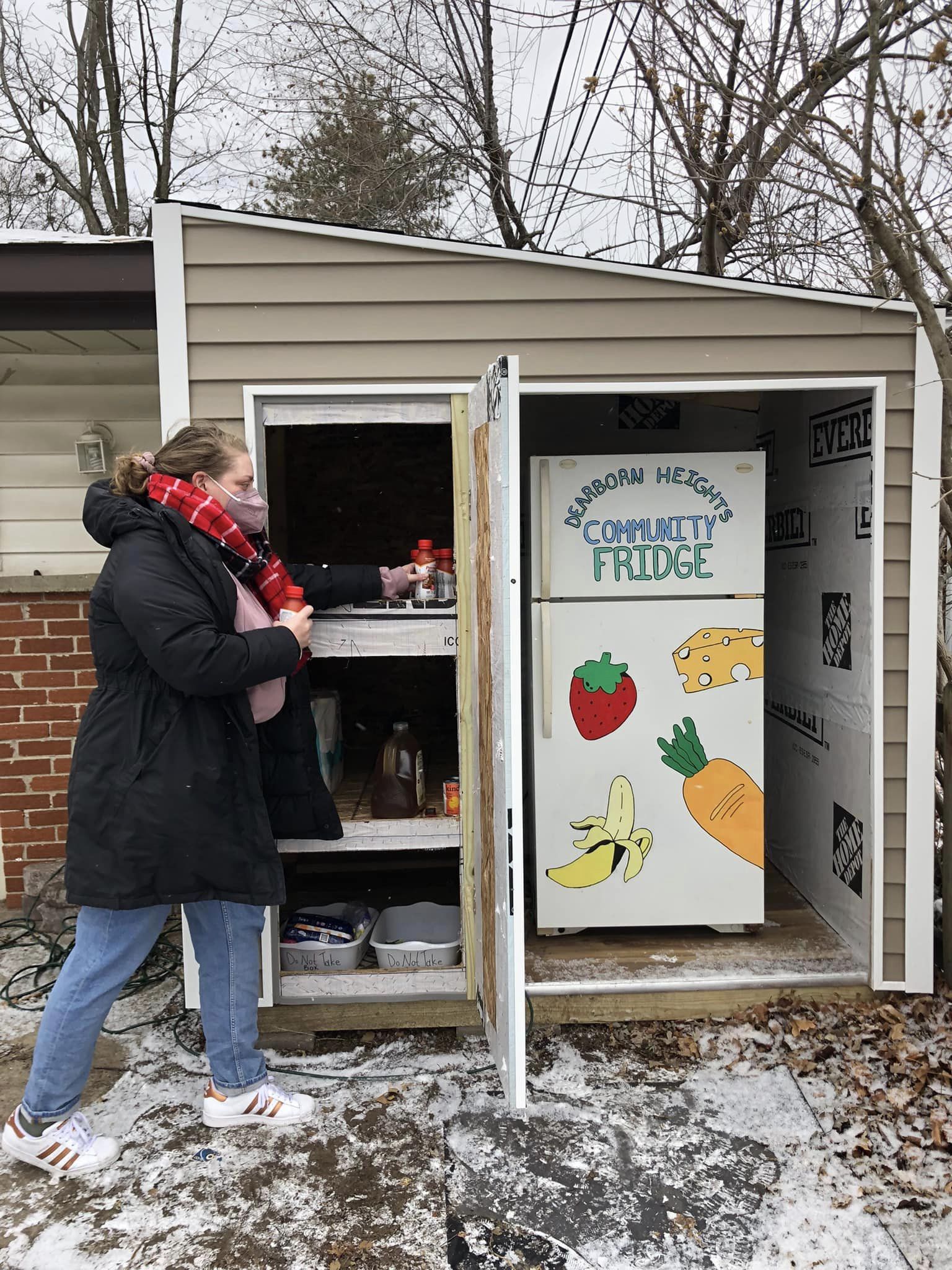 Woman stocking the food pantry and community fridge