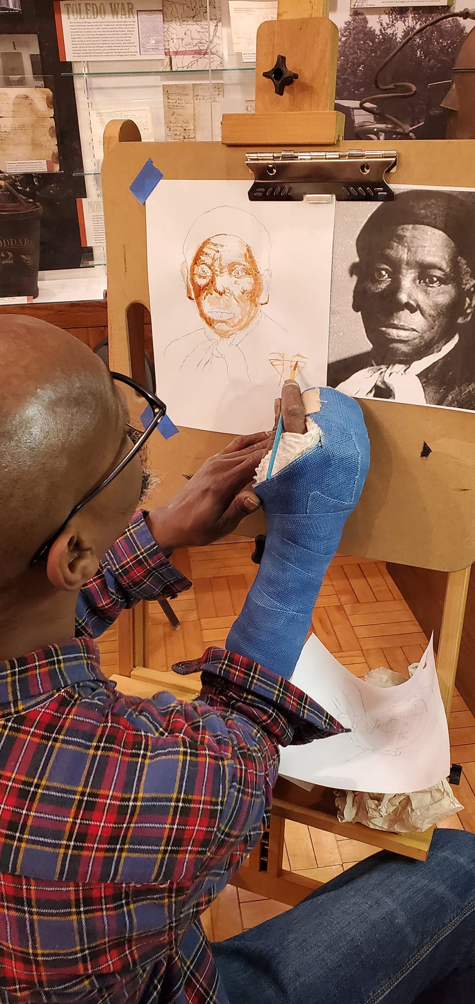 Man painting a portrait of Harriet Tubman