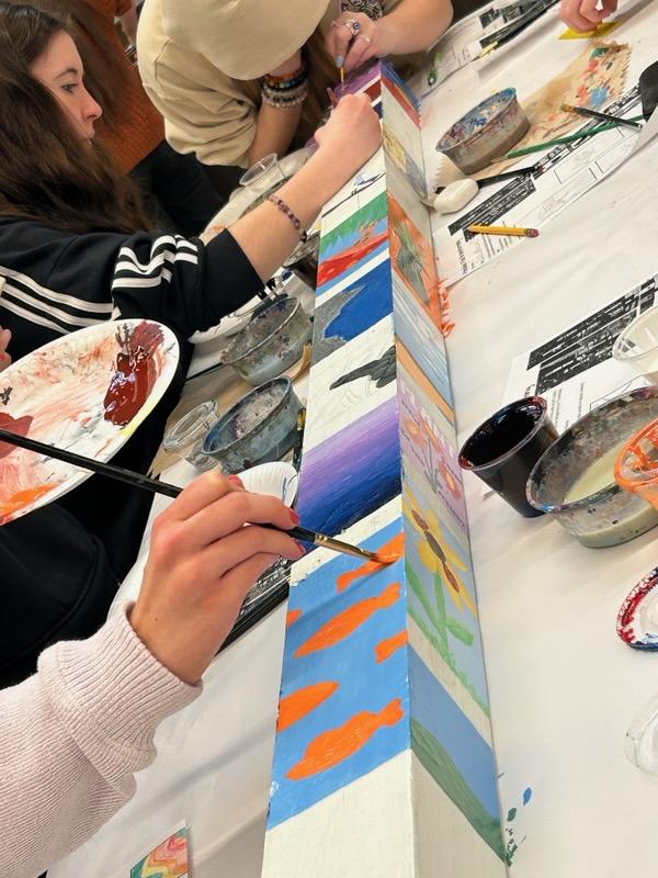 People painting a Friendship Pole