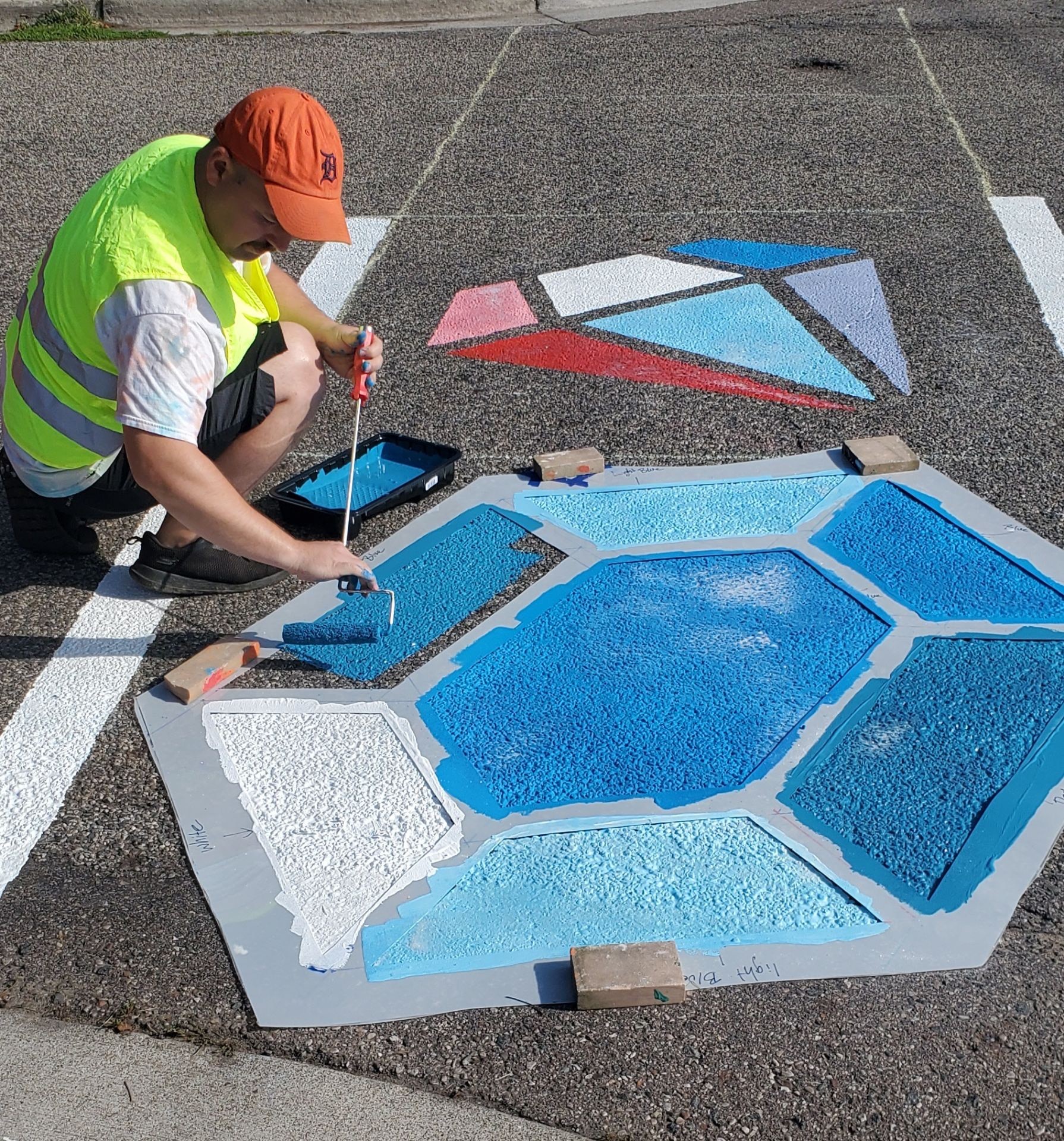 Man painting a mural on a crosswalk