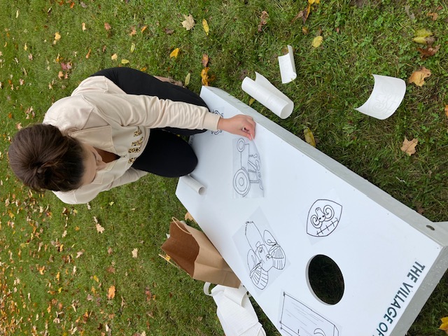 Woman decorating a corn hole board