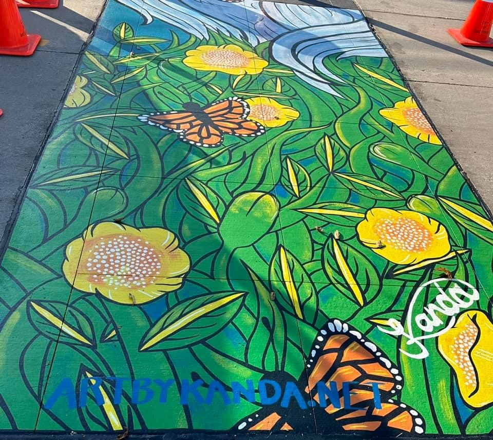 Mural of flowers and butterflies painted on to a crosswalk