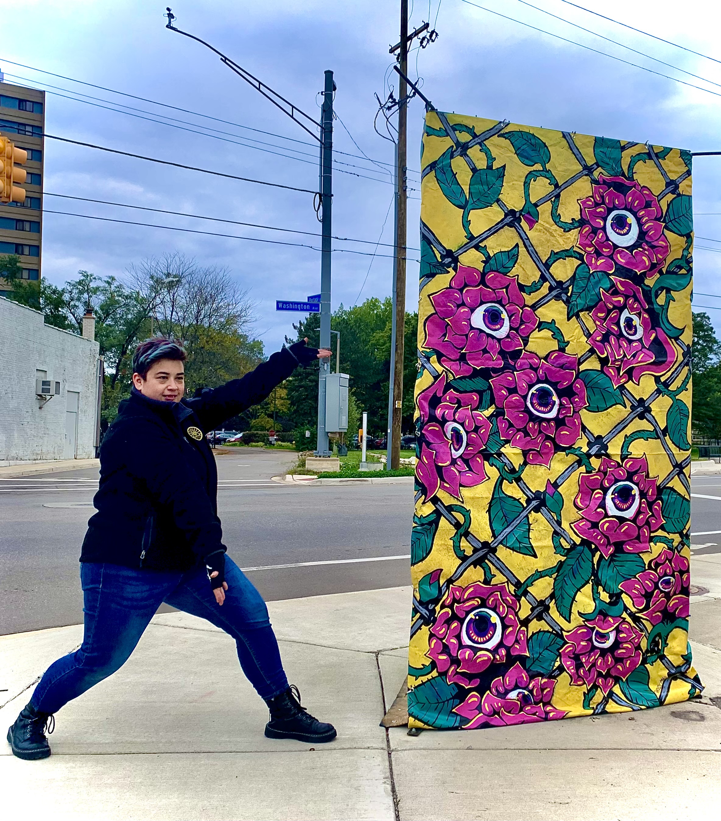 Person pointing to a mural of flowers with eyes